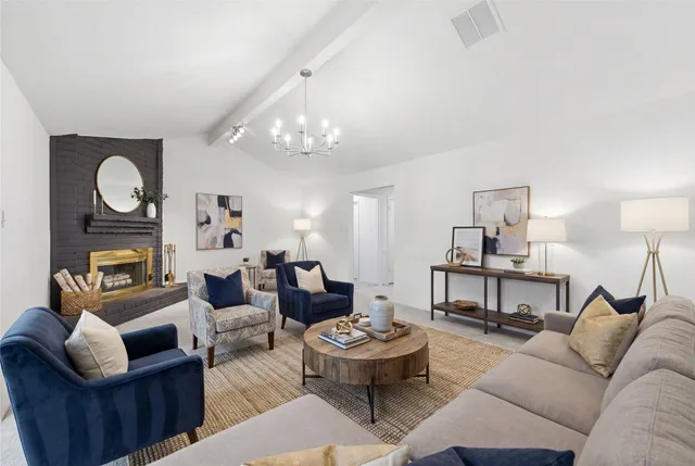 a living room with fireplace furniture and a chandelier