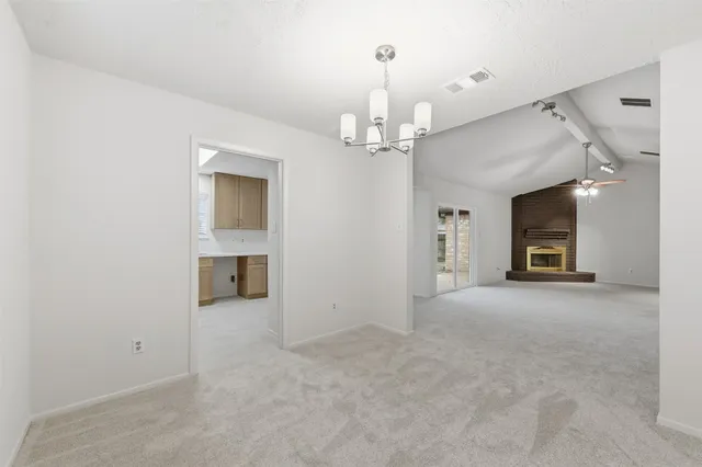 en empty room with windows and fireplace