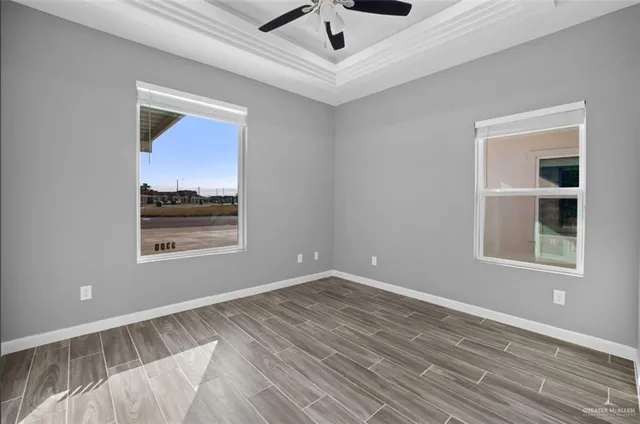 a view of an empty room with window and wooden floor