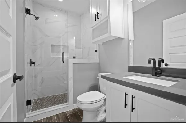 a bathroom with a sink toilet vanity and shower