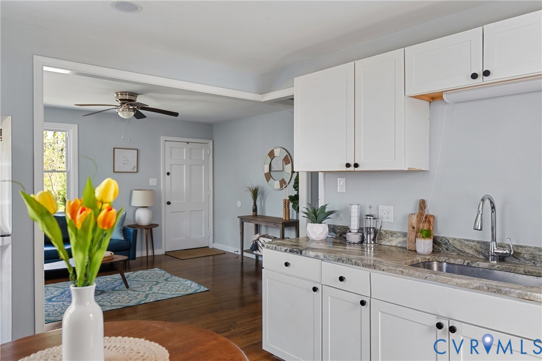 2700 Berry Road Richmond, VA 23234 - Photo 21 of 46 a kitchen with stainless steel appliances granite countertop a sink a stove a dining table and chairs with wooden floor