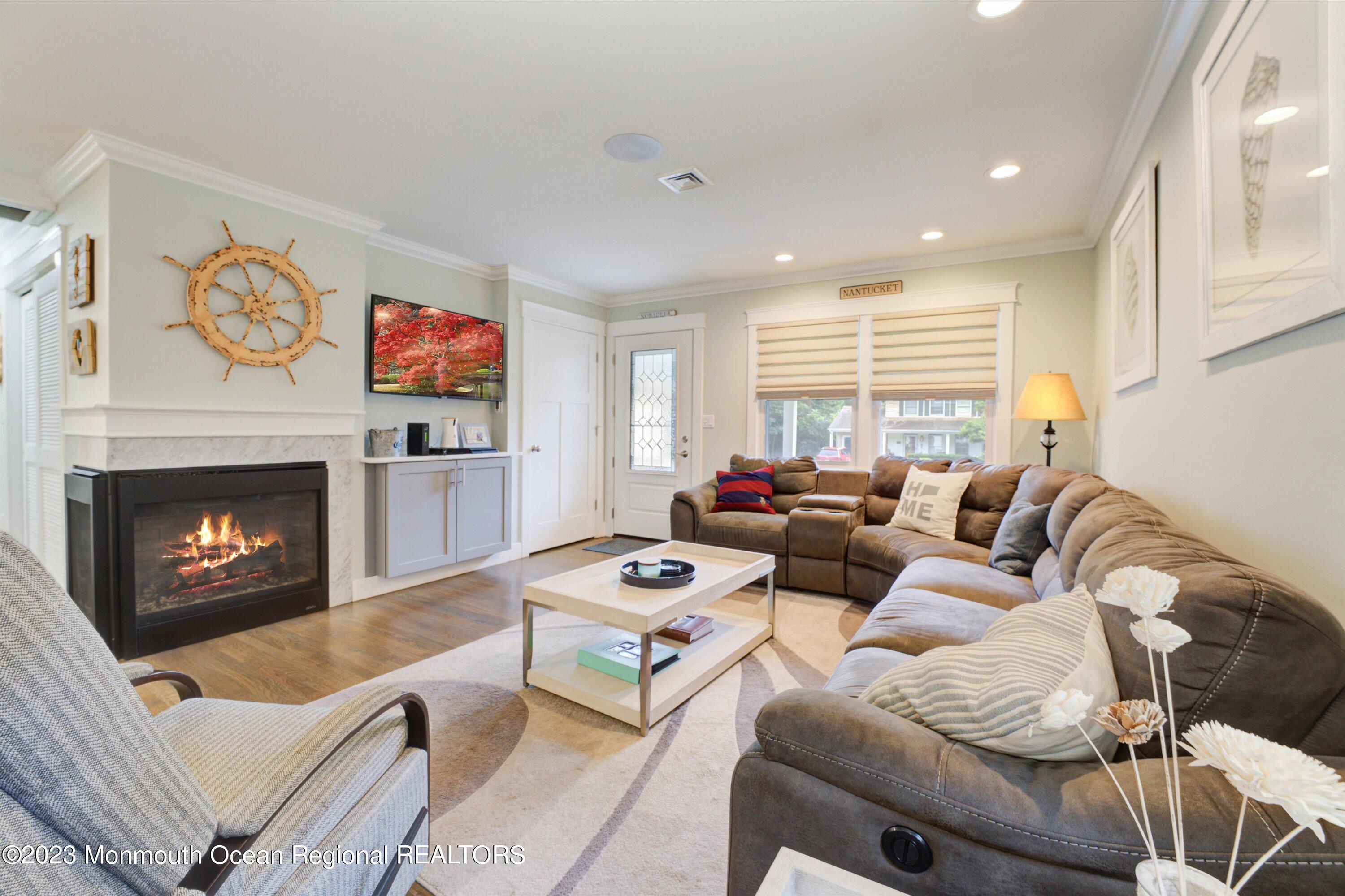 100 Manito Road Manasquan, NJ 08736 - Photo 4 of 28 a living room with furniture a fireplace and a flat screen tv