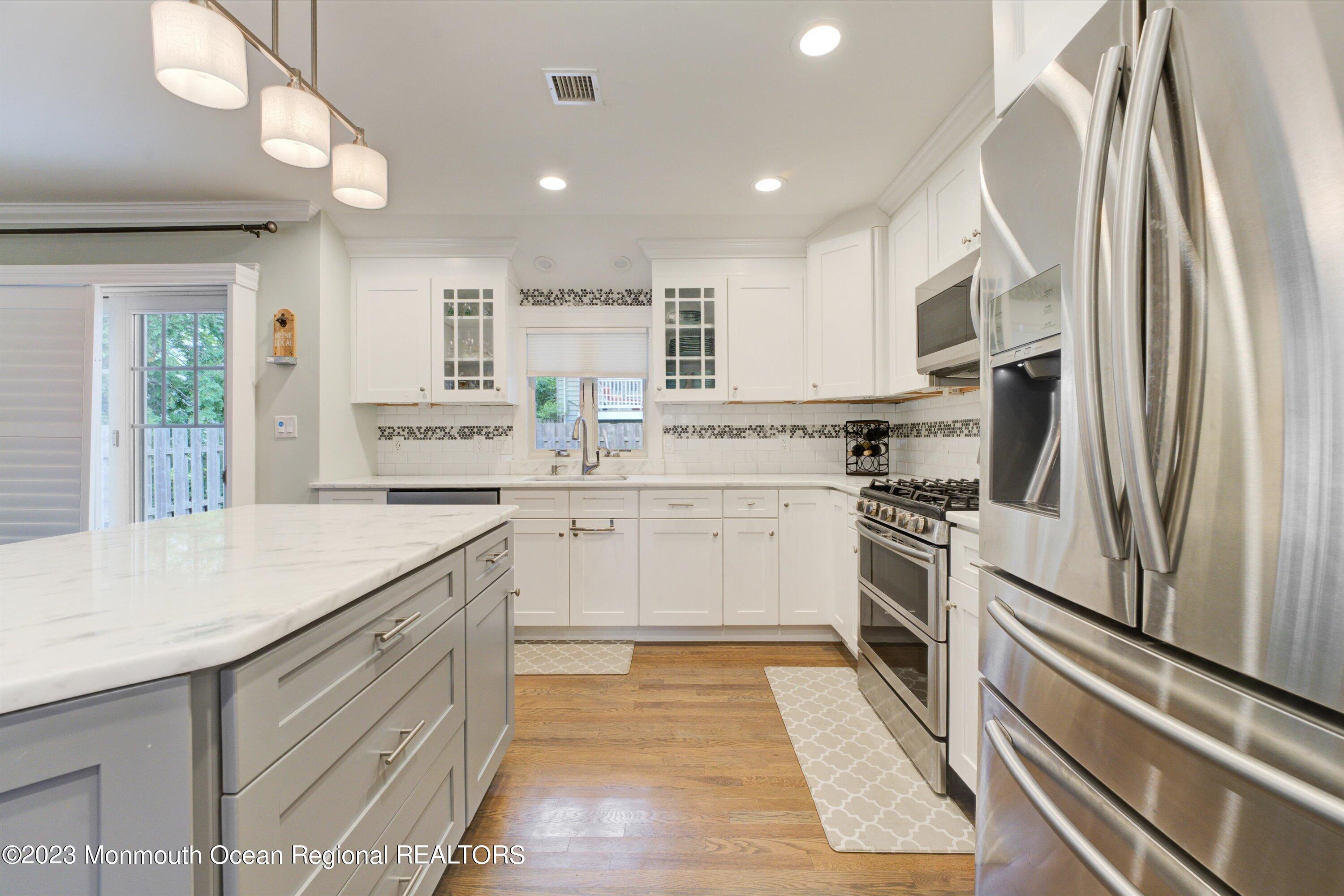 100 Manito Road Manasquan, NJ 08736 - Photo 8 of 28 a kitchen with white cabinets and stainless steel appliances