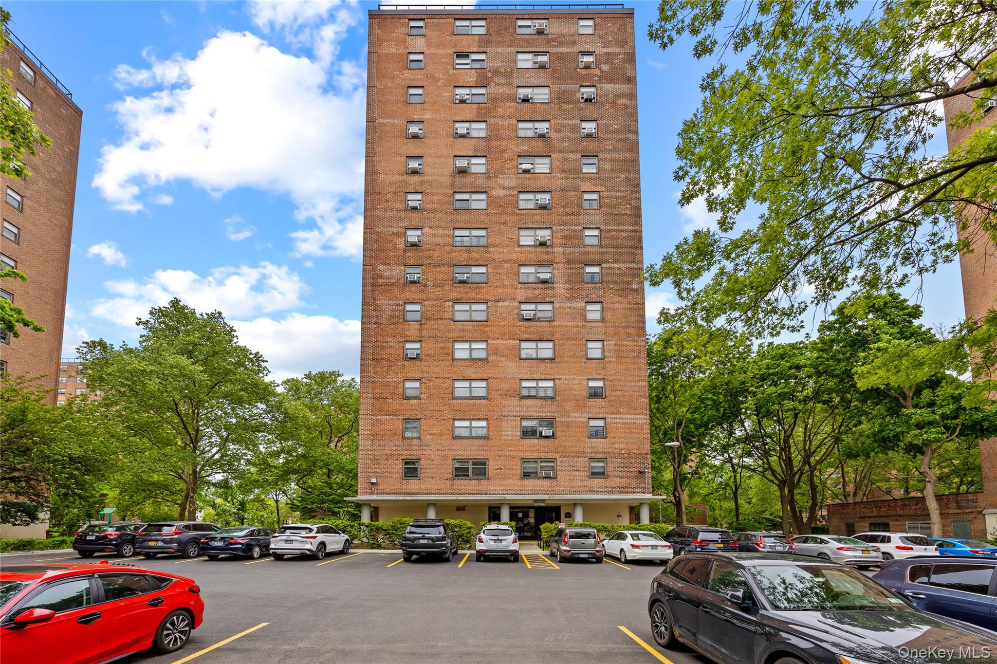 21-66 33rd Road, Unit 12B Queens, NY 11106 - Photo 22 of 23 a city street lined with parked cars and buildings