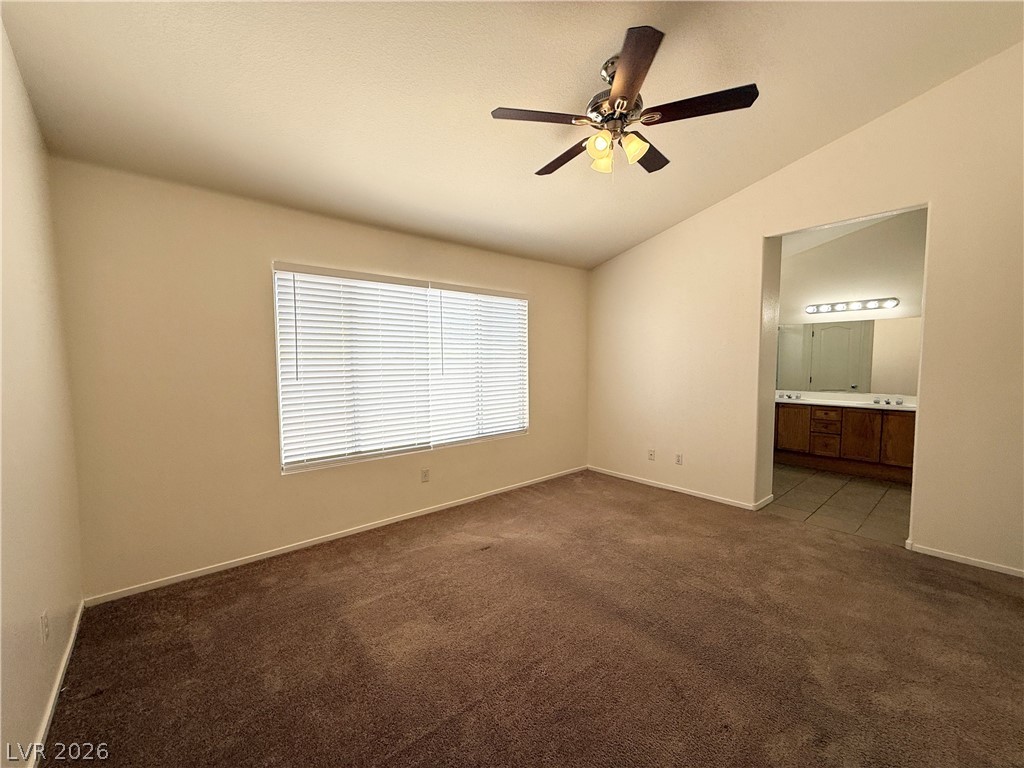 8870 Haviland Road Las Vegas, NV 89123 - Photo 17 of 24 A well-lit bedroom features plush carpeting and convenient access to an en-suite bathroom.