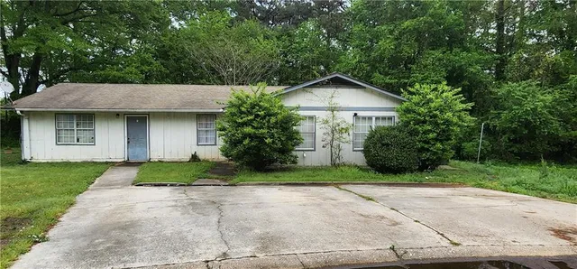 a front view of a house with a yard and trees