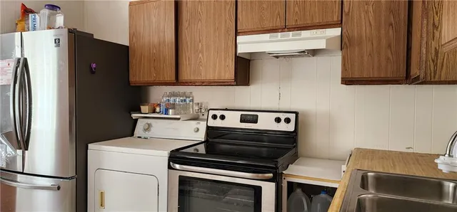 a kitchen with wooden cabinets and a stove top oven