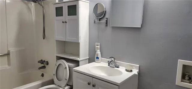 a bathroom with a sink toilet and a mirror