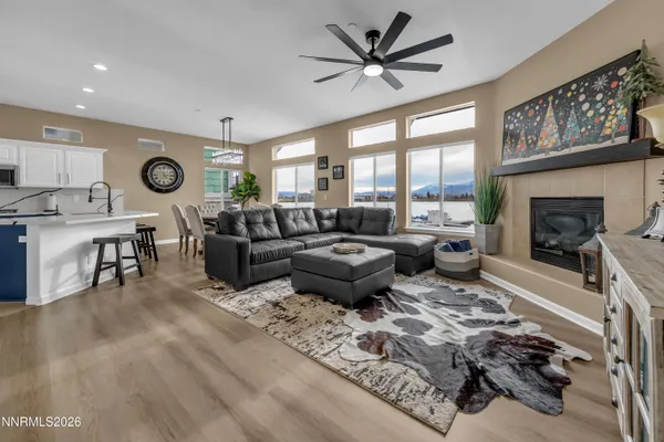 a kitchen with stainless steel appliances kitchen island a table chairs in it and wooden floors