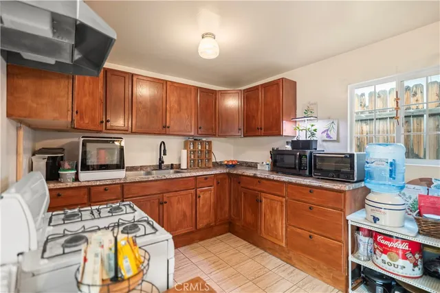 a kitchen with stainless steel appliances granite countertop a sink dishwasher stove and cabinets with wooden floor