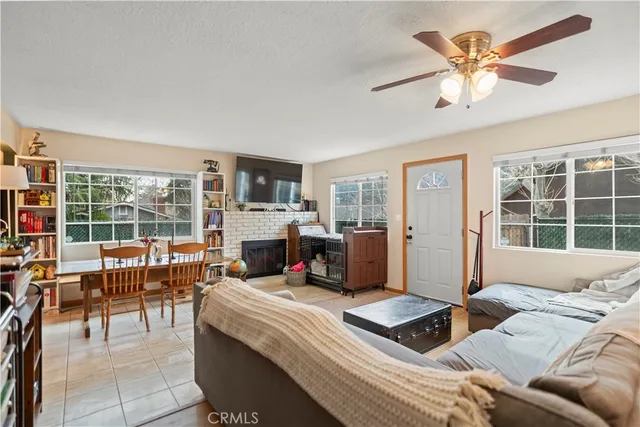 a living room with furniture a flat screen tv and a large window