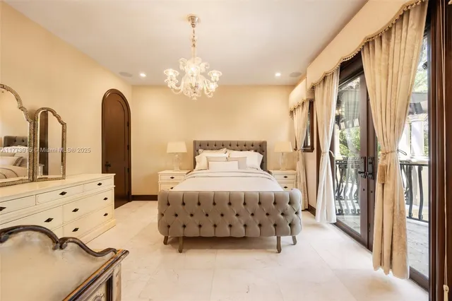 a spacious bedroom with a bed and a chandelier