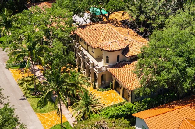 an aerial view of a house with swimming pool and trees