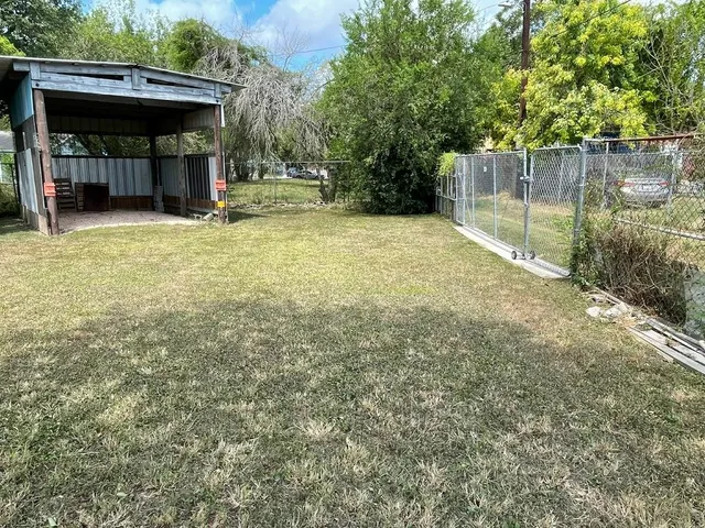 a view of a yard with a small cabin and a chair