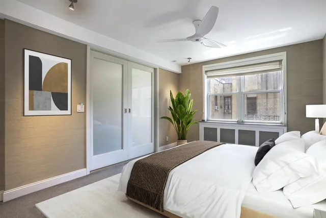 a bedroom with a bed and a large window