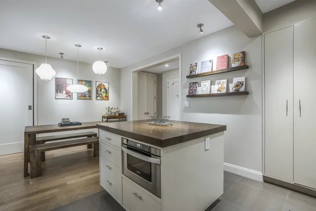 a kitchen with a stove and a wooden floor