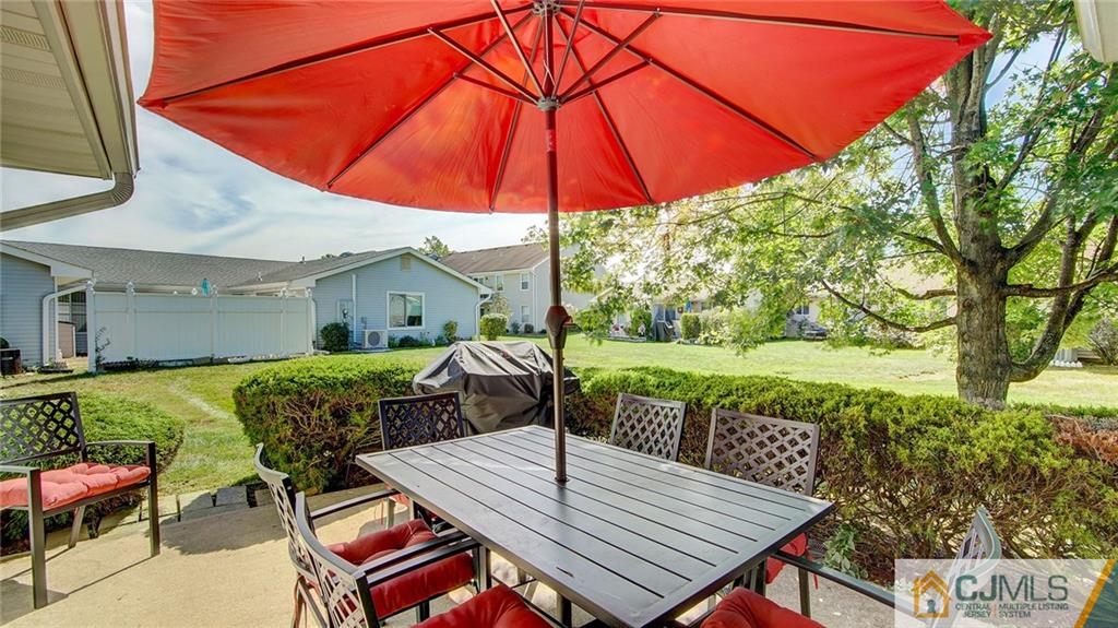 801 A Pompton Road, Unit 801A Monroe Township, NJ 08831 - Photo 16 of 33 a patio with a table and chairs under an umbrella