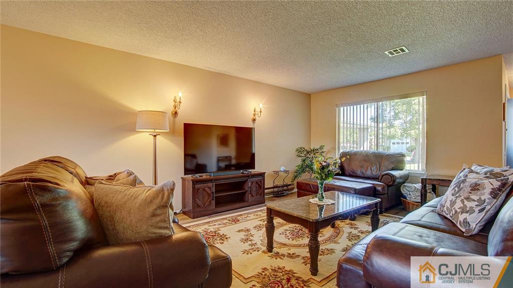 801 A Pompton Road, Unit 801A Monroe Township, NJ 08831 - Photo 7 of 33 a living room with furniture and a flat screen tv