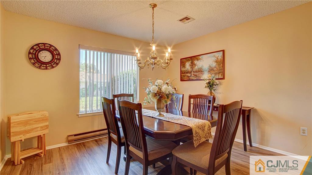 801 A Pompton Road, Unit 801A Monroe Township, NJ 08831 - Photo 9 of 33 a view of a dining room with furniture and chandelier