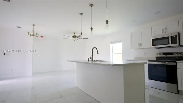 a kitchen with cabinets a window and stainless steel appliances