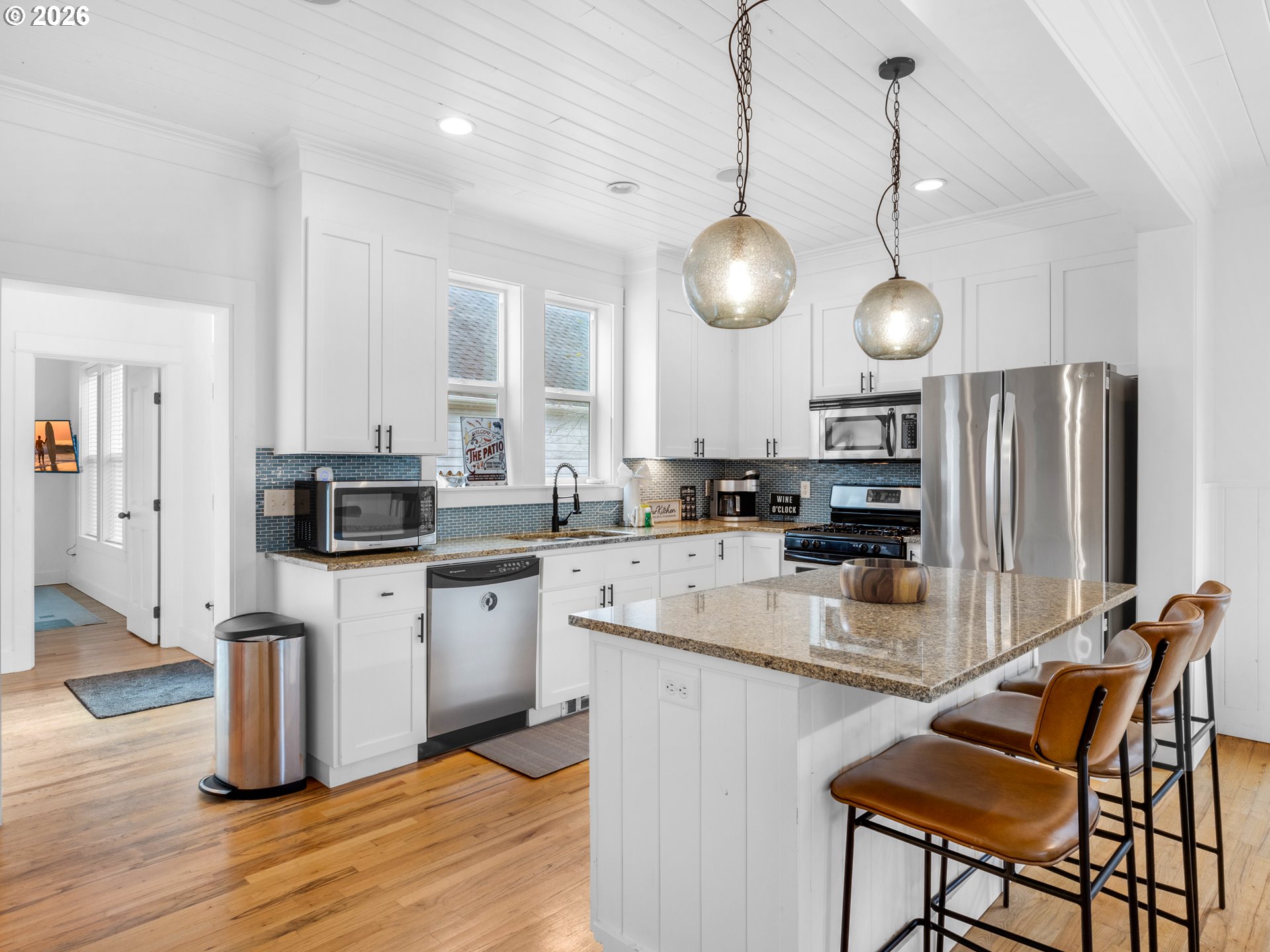 2746 Southwest Barnacle Avenue Lincoln City, OR 97367 - Photo 14 of 48 a kitchen with stainless steel appliances granite countertop a stove top oven a refrigerator a sink and white cabinets with wooden floor