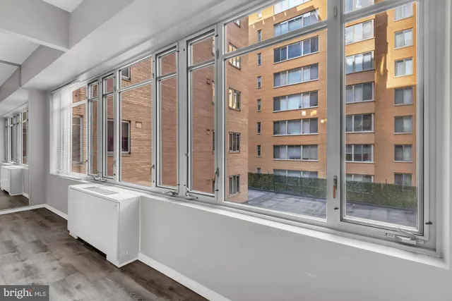a view of an entrance to house with wooden floor and windows