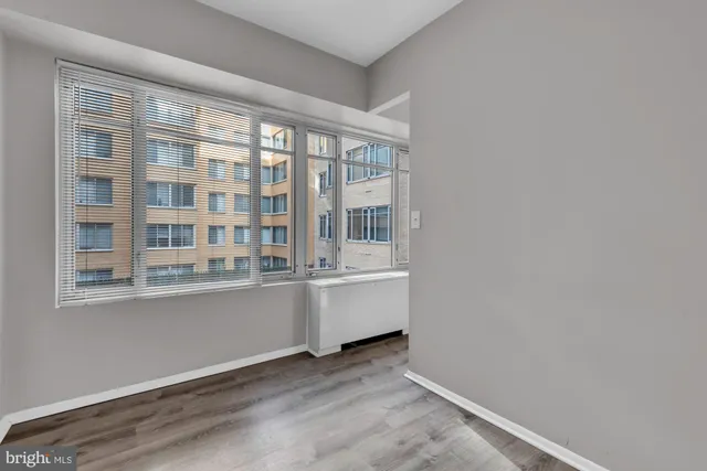 an empty room with wooden floor and a window