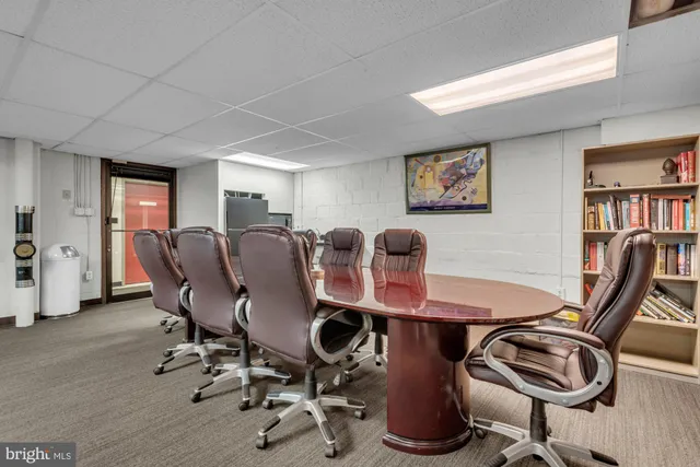 a view of a workspace with furniture and a bookshelf