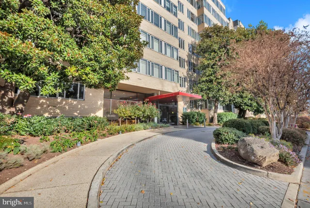 a view of a street with a building and trees in the background