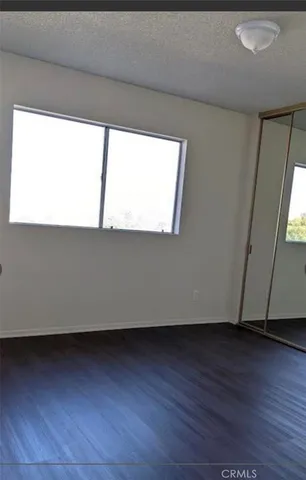 a view of a room with wooden floor and a window