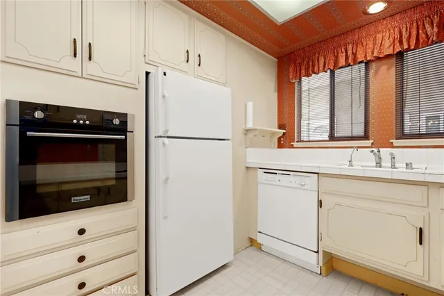 a kitchen with white cabinets and white appliances