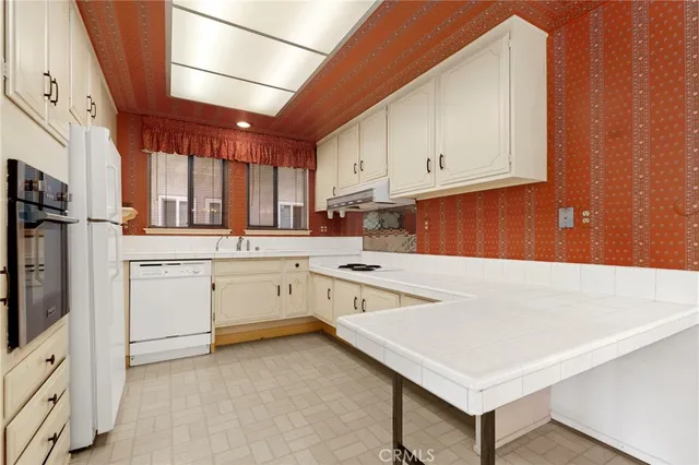 a kitchen with white cabinets and white appliances