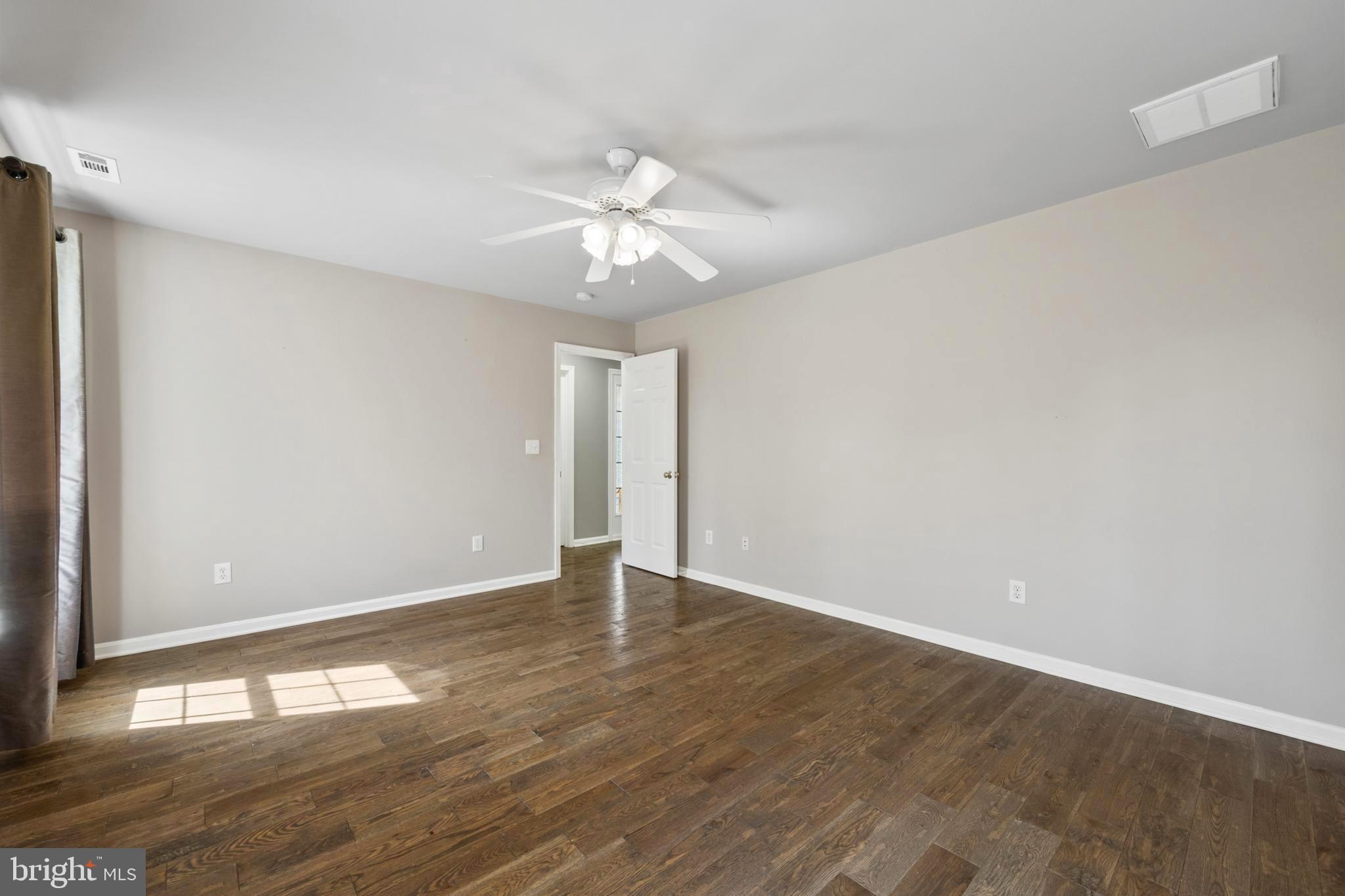 203 Birdie Road Locust Grove, VA 22508 - Photo 23 of 46 a view of an empty room with wooden floor and a ceiling fan