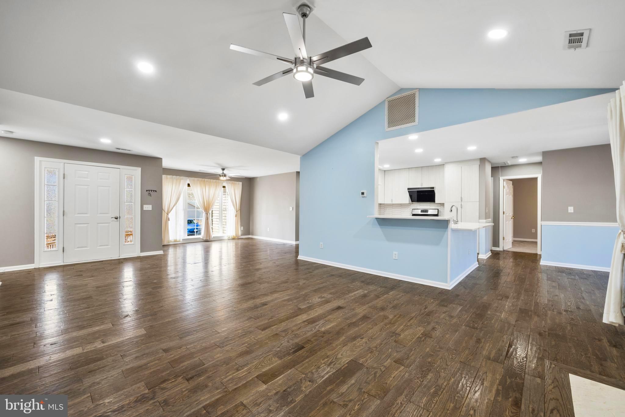 203 Birdie Road Locust Grove, VA 22508 - Photo 6 of 46 a view of an empty room with wooden floor and a kitchen