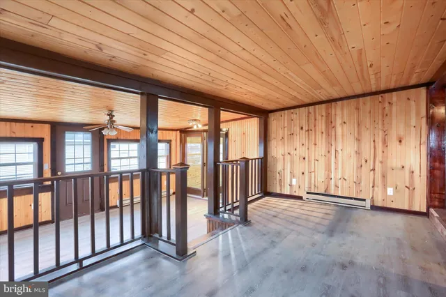 a view of a room with wooden floors and windows