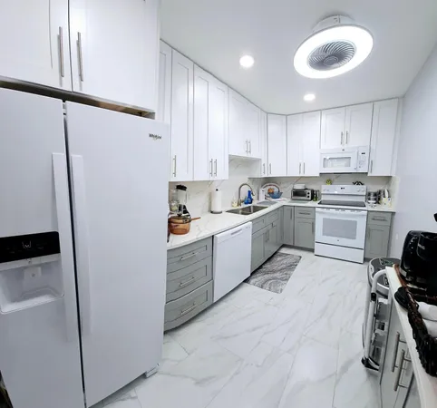 a kitchen with white cabinets and white appliances
