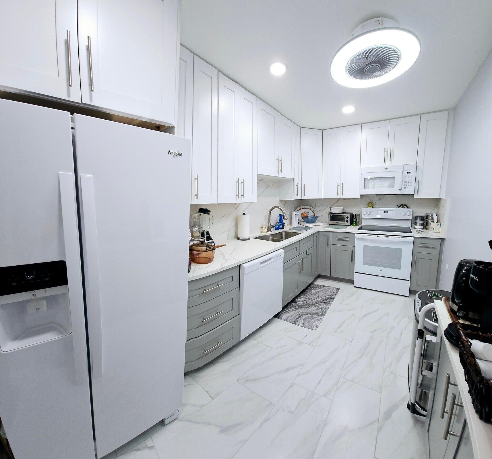 10126 South 44th Terrace Boynton Beach, FL 33436 - Photo 6 of 30 a kitchen with white cabinets and white appliances