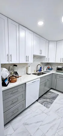 a kitchen with granite countertop a sink stainless steel appliances and cabinets