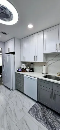 a kitchen with a refrigerator sink and cabinets