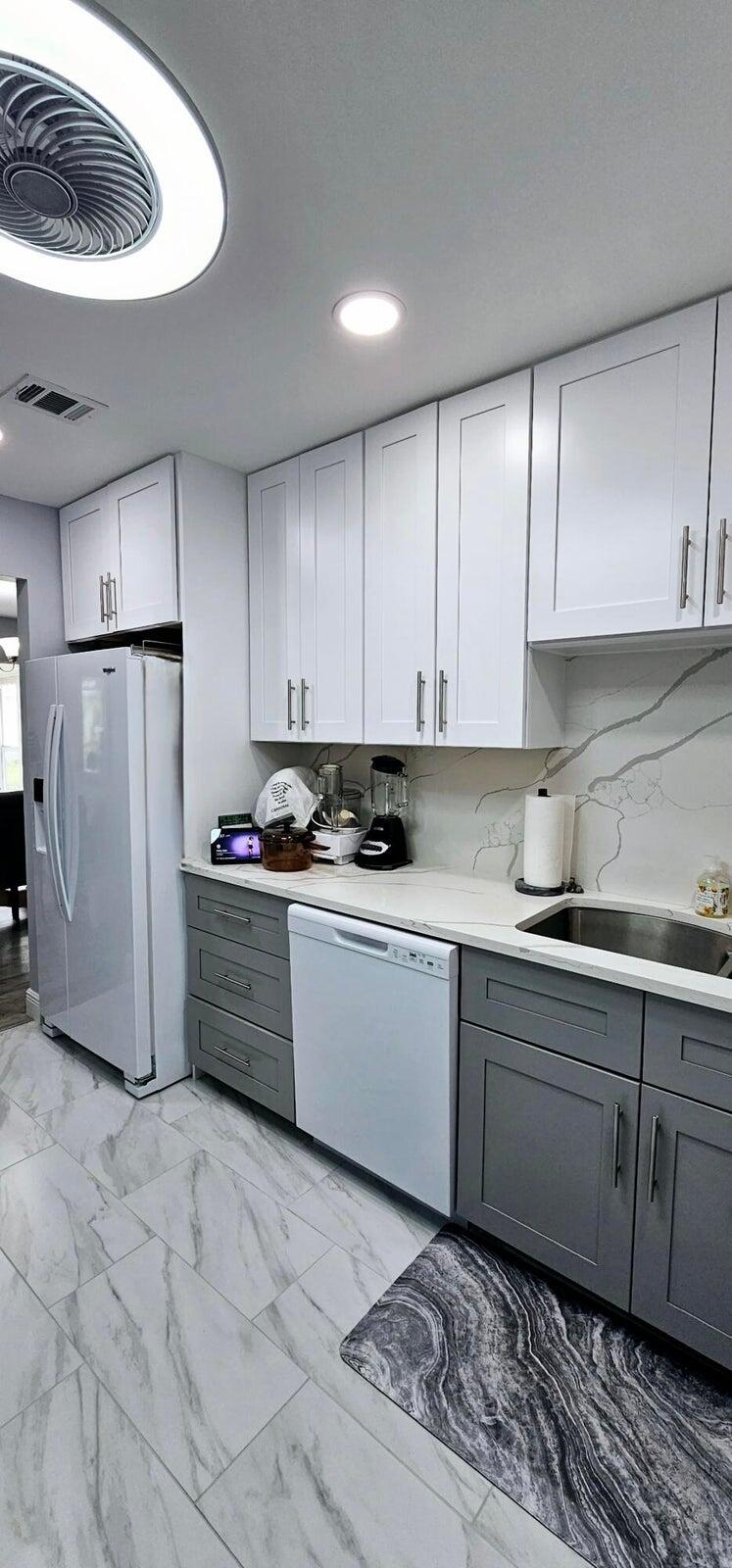 10126 South 44th Terrace Boynton Beach, FL 33436 - Photo 9 of 30 a kitchen with a refrigerator sink and cabinets