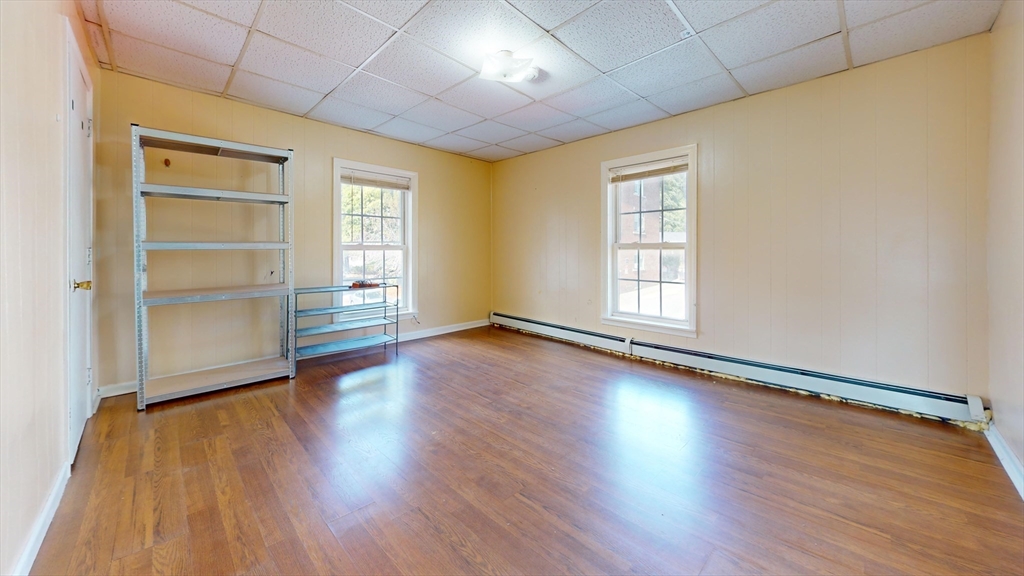 1022 Main Street Worcester, MA 01603 - Photo 26 of 40 an empty room with wooden floor closet and windows