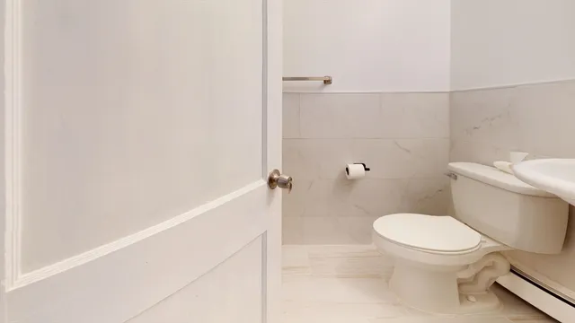 a white toilet sitting next to a shower