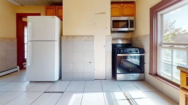 a kitchen with stainless steel appliances a refrigerator and a stove top oven