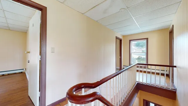 a view of a hallway with wooden floor and stairs