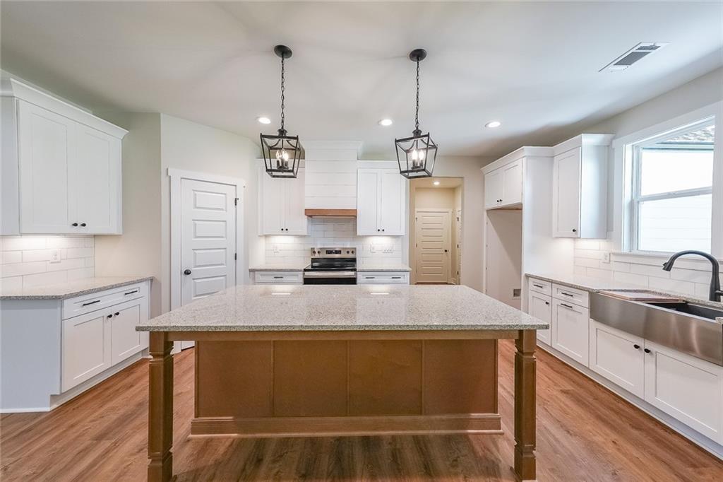 3300 Holly Springs Road Rockmart, GA 30153 - Photo 11 of 38 a large kitchen with granite countertop a sink stainless steel appliances and cabinets