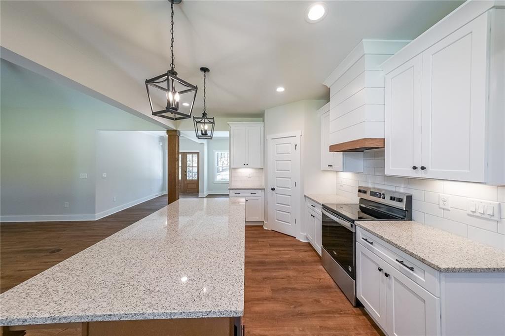 3300 Holly Springs Road Rockmart, GA 30153 - Photo 12 of 38 a kitchen with stainless steel appliances granite countertop a sink a stove top oven a counter space and cabinets