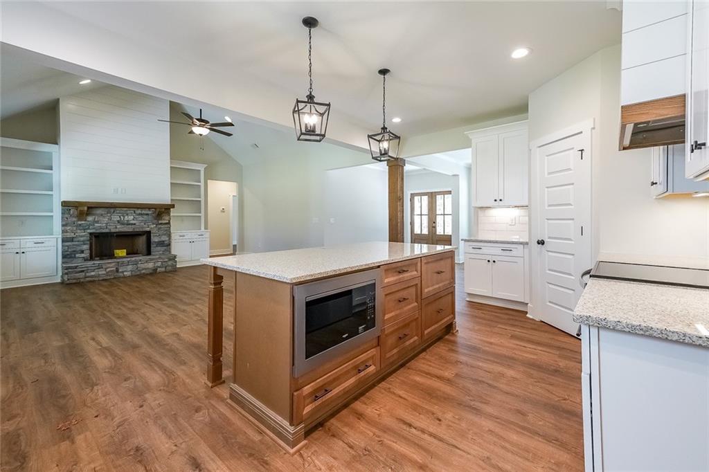 3300 Holly Springs Road Rockmart, GA 30153 - Photo 13 of 38 a kitchen with stainless steel appliances a stove top oven a refrigerator and a fireplace
