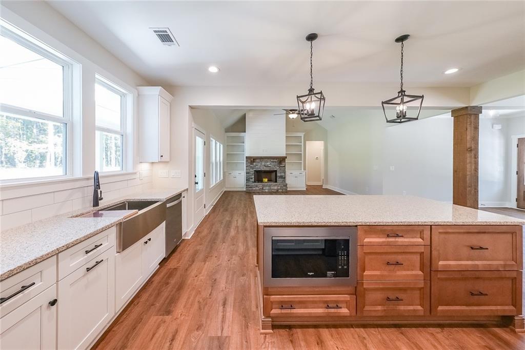 3300 Holly Springs Road Rockmart, GA 30153 - Photo 14 of 38 a large kitchen with stainless steel appliances granite countertop a stove and a wooden floors