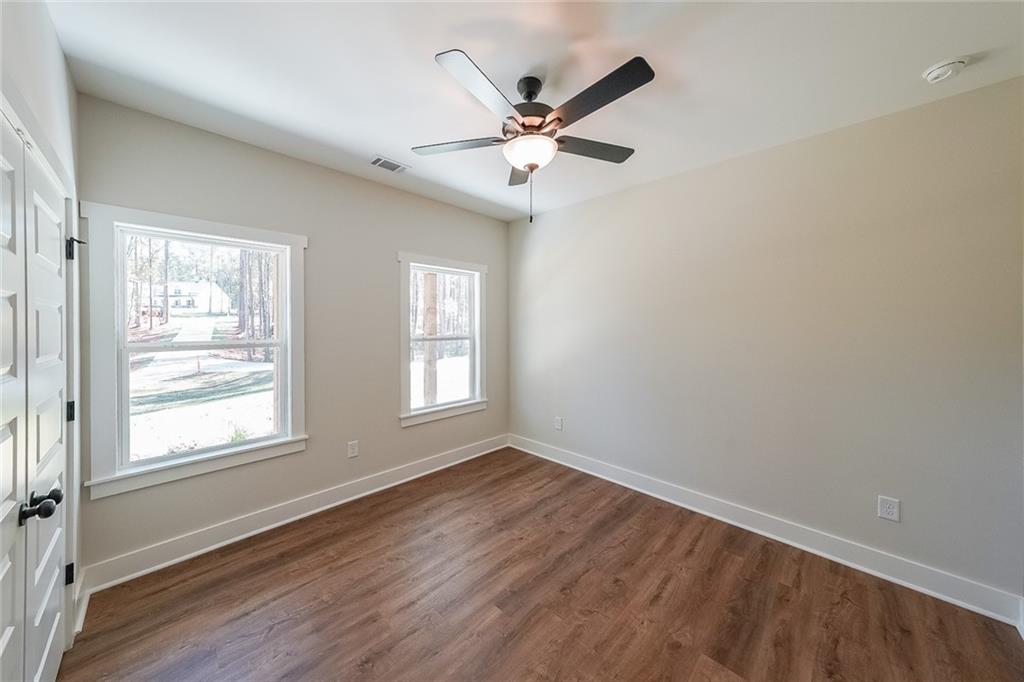 3300 Holly Springs Road Rockmart, GA 30153 - Photo 30 of 38 a view of wooden floor and a chandelier fan in a room