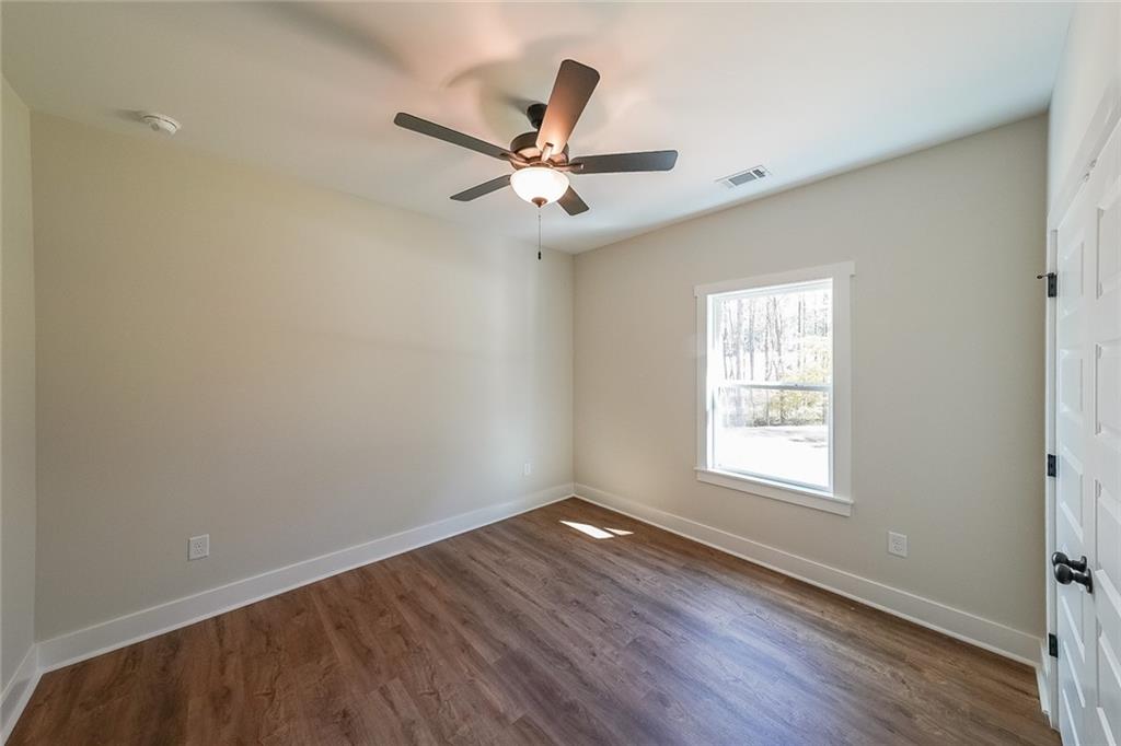 3300 Holly Springs Road Rockmart, GA 30153 - Photo 31 of 38 an empty room with wooden floor fan and windows